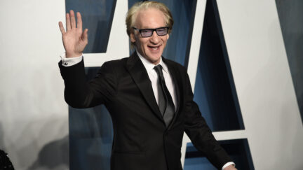 Bill Maher in a suit waving as he arrives at 2022 Oscars after party